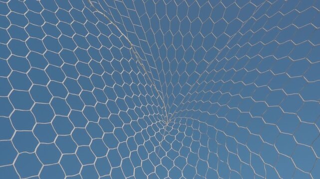 White synthetic football goal net with a hexagonal mesh pattern stands out against the azure sky.