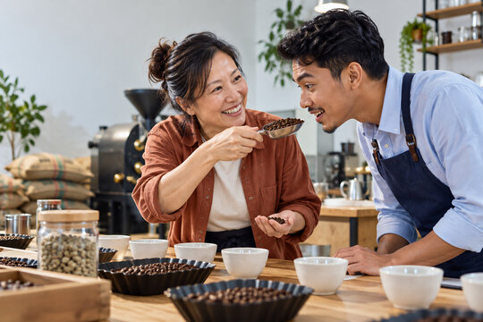 Customer and barista smell roasted coffee in a roastery