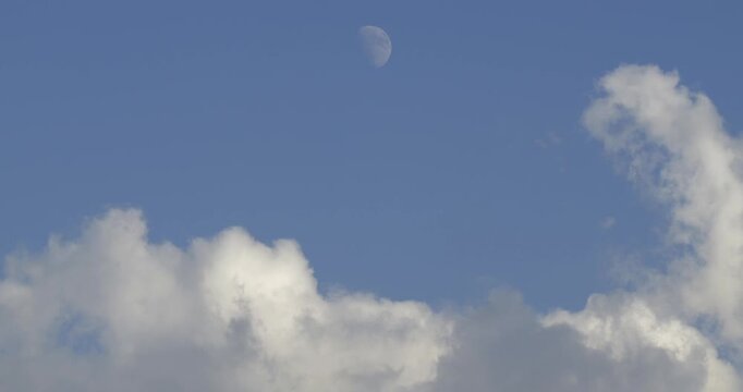 Full moon footage in cloudy blue sky during daytime.