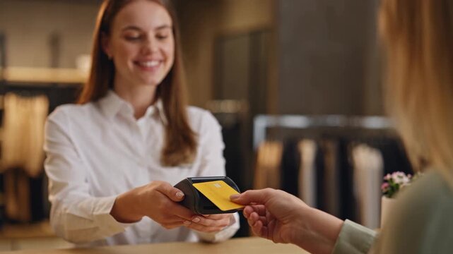Customer Making Contactless Credit Card Payment to Cashier using POS Terminal at Boutique
