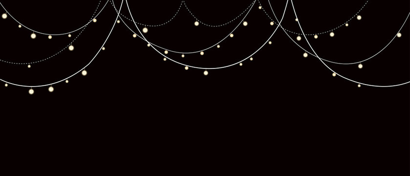 Glowing string lights hanging against a dark black night background