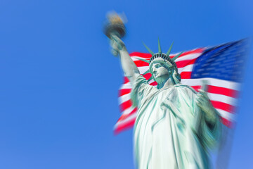 Statue of Liberty with a large american flag with motion blur effect © Maria