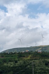Wind farm above a green hillside at Cau Dat in Vietnam © IbragimovN