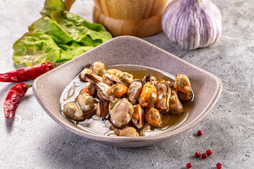 Red chili peppers and garlic with cooked mussels in ceramic bowl on gray stone table seafood appetizer © Andrei Starostin