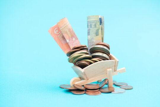 Pile of money in a wheelbarrow, finance and economy concept, savings of society, inflation, loan for family, income budget, euro banknotes and coins