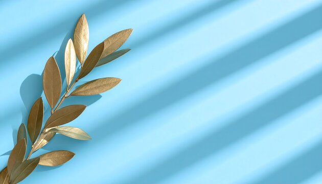 Golden olive branch on light blue background with dramatic window shadows, elegant metallic leaf branch minimal layout with copy space