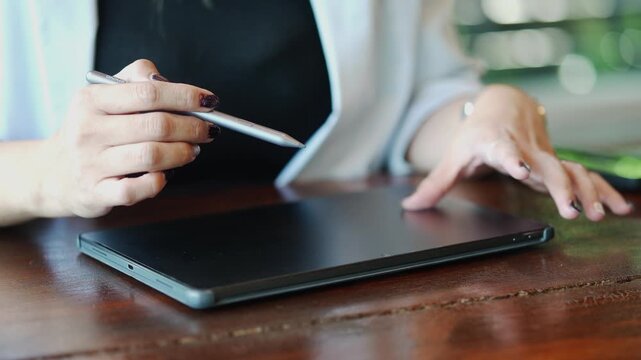 Close Up Hands Using Stylus on Digital Tablet
