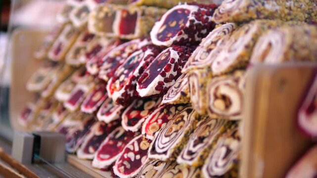 Decorated holiday cookies fill bakery display, offering festive treats for seasonal gifting. Rows of iced biscuits feature intricate red, white, and gold patterns, arranged for shoppers to choose.