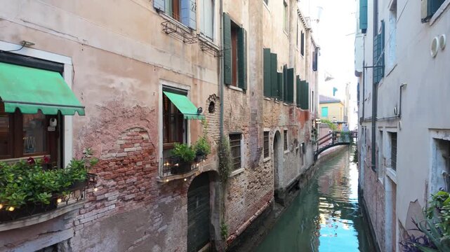 Narrow urban canal flowing between weathered historic buildings