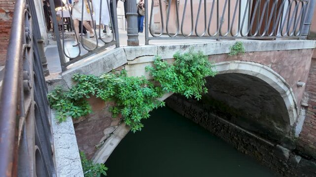 Venice canal beneath a historic stone footbridge