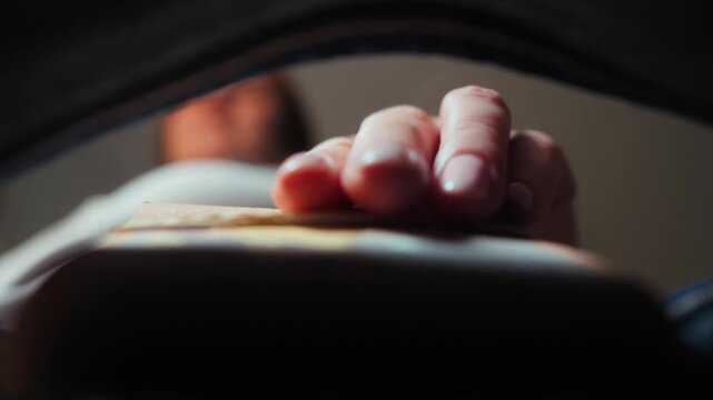 Close-up of hand pulling money from jeans pocket. Soft focus shot of cash stack being taken out, finance and lifestyle footage. High quality 4k footage