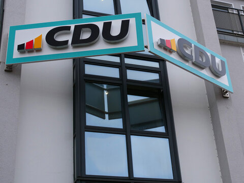 CDU (Christian Democratic Union of Germany) party logo signs mounted at an angle on the outside wall of a modern office building