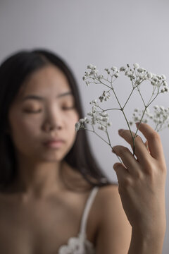 Young Southeast Asian woman holding delicate white baby's breath