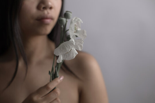 Southeast Asian woman holding white flower in intimate portrait