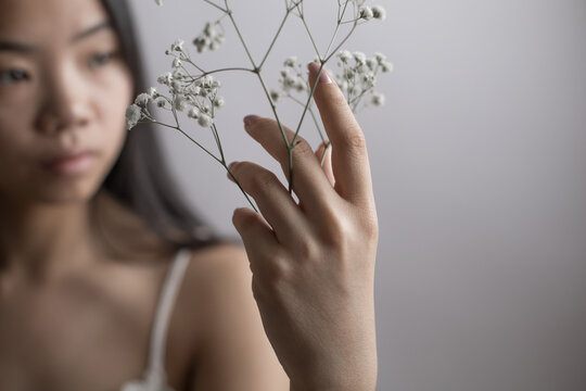 Southeast Asian woman holding delicate white flowers