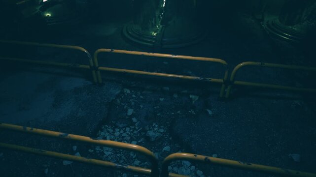 This scene showcases a dimly lit underground location featuring a barrier surrounding a cracked and rocky surface. The eerie atmosphere adds to its allure and intrigue, highlighting decay.