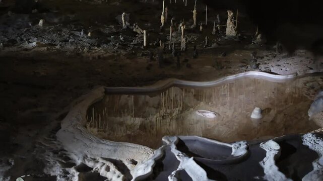 Limestone cave with stalactites, stalagmites, and water. Cave exploration, scientific research, environmental education. Provence, France. 