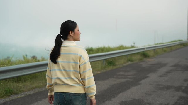woman walking on a road on mountain in the morning