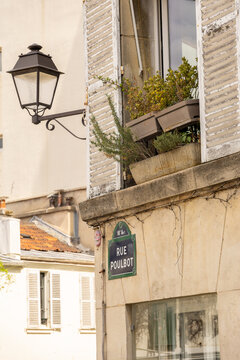 Street sign and vintage lantern on a building in Paris France