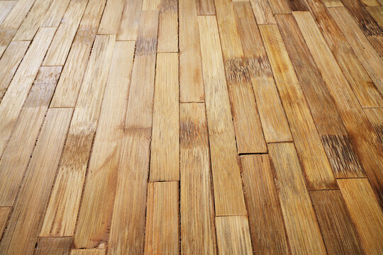Natural light brown bamboo flooring planks stacked vertical parallel light texture pattern.