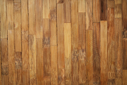 Natural light brown bamboo flooring planks stacked vertical parallel light texture pattern.