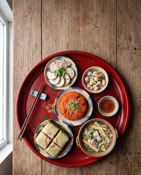 Vietnamese Tet family feast on red lacquer tray with gio lua, xoi gac, pickled shallots and banh chung
