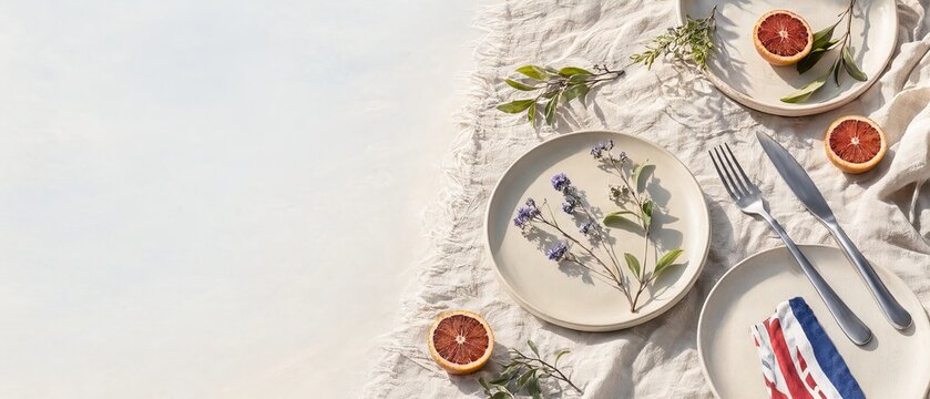 Minimalist summer tablescape on linen with blood oranges. botanical elements and modern tableware.