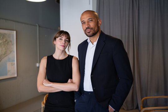 Confident executives standing with crossed arms in the office