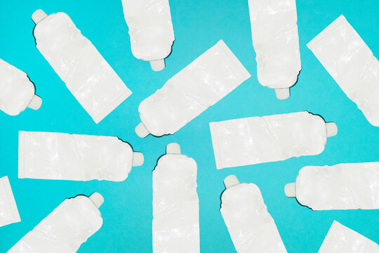 Empty white aluminium paint tubes lie scattered on a blue background