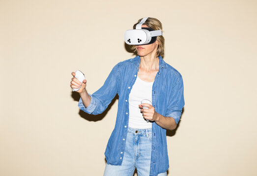 Woman plays virtual reality game with headset and controller