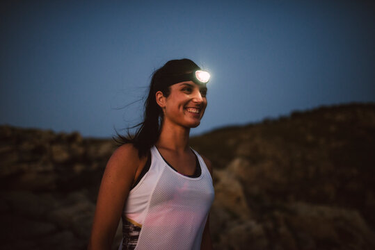 Sportive woman with headlamp in the evening