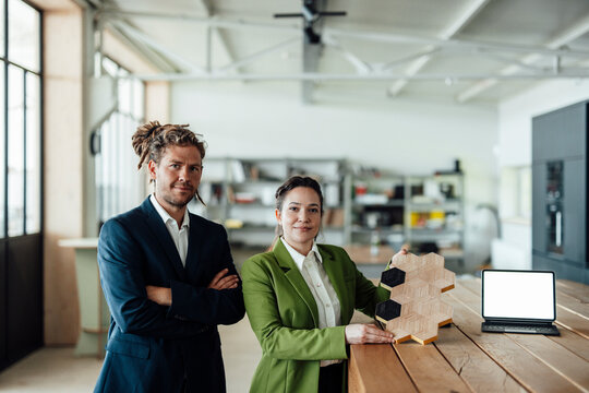 Man and woman present sustainable wood design in modern office