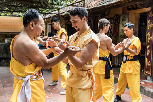 Vietnam, Hanoi, men exercising kung fu, european man learning kung fu