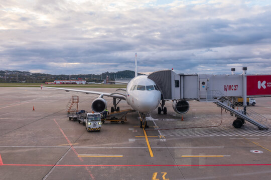 Sochi, Russia - October 23, 2025: Boarding a plane through a gate at Sochi Airport. An airplane with the inscription smartavia and a teleport attached to it stands at the airport on a cloudy day