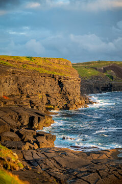 Dramatic coastal landscape along the Wild Atlantic Way during golden hour. Rugged Kilkee Cliffs on the Loop Head Peninsula in County Clare, Ireland.