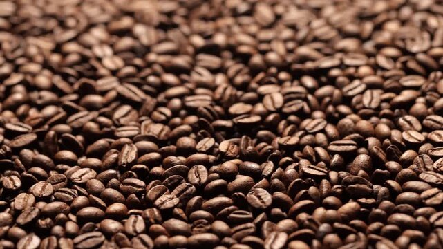 Roasted coffee beans in motion &ndash; close-up (macro) of the texture and brown shades of the beans.