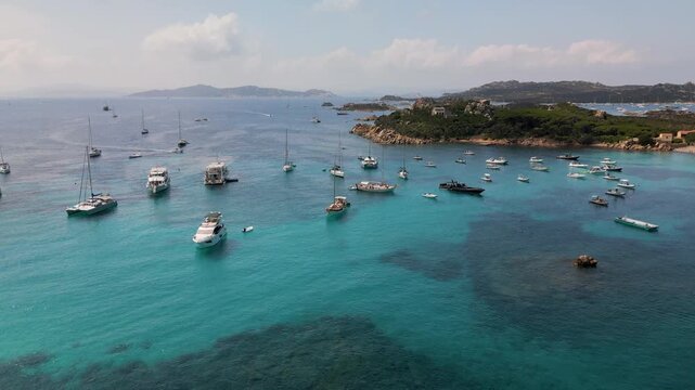 Aerial  view of the turquoise bay with a rocky coastline with yachts and boats off the coast of Spargi Island in the La Maddalena archipelago, Sardinia, Italy