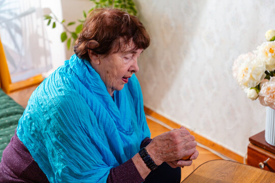 Senior woman engaged in a dice game at home. Calm focus and routine. Concept of lifestyle and comfort. Mid shot
