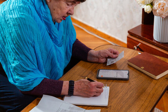Senior female managing personal budget and tracking expenses indoors. Practical lifestyle and responsibility. Concept of retirement savings and control. Mid shot