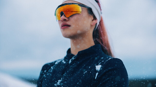 Athlete posing confidently in snowy winter landscape with sportswear
