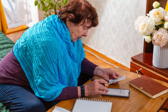 Senior female organizing receipts and bills. Practical routine and hardship. Concept of economic struggle. Top view