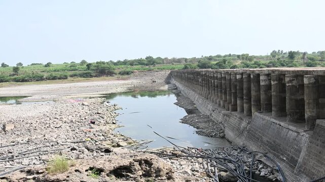 completely dry rocky riverbed winding through a parched rural landscape. This footage highlights severe drought, water scarcity, and the impact of climate change.