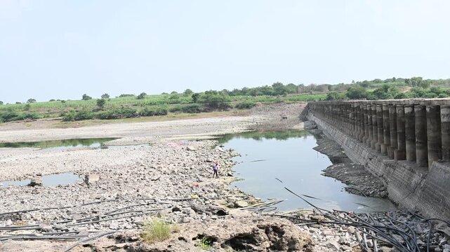 completely dry rocky riverbed winding through a parched rural landscape. This footage highlights severe drought, water scarcity, and the impact of climate change.