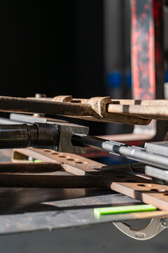 Close view of rusty metal tooling and square tube offcuts on a workbench