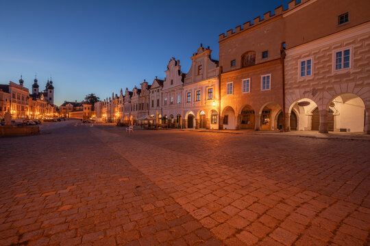 03 October 2026, Colorful Renaissance houses with arcades line the cobblestone main square after sunset in Telč, Czech Republic.