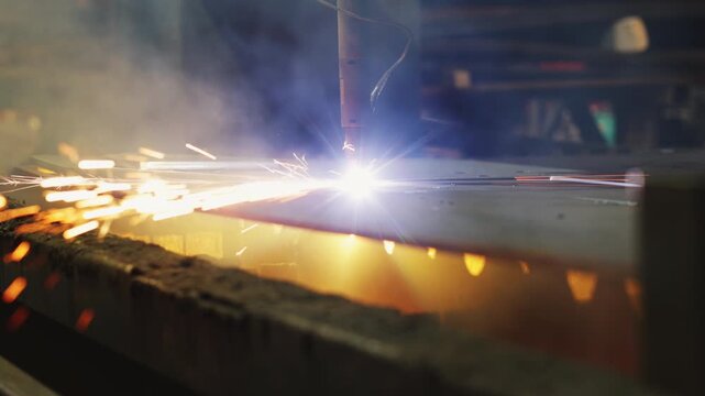 A laser slices through metal, scattering bursts of bright sparks. Factory automation, pinpoint precision, and next-generation machinery for metalworking