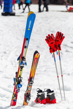 Colourful skis, boots, poles and gloves standing upright in fresh snow at Whakapapa Ski Field on Mount Ruapehu, New Zealand