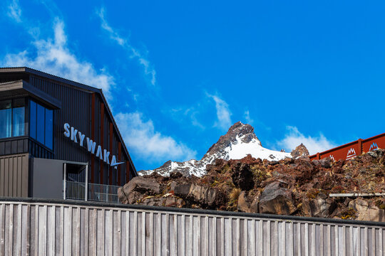 Sky Waka terminal building beneath snow-covered volcanic peaks on Mount Ruapehu at Whakapapa Ski Field in Tongariro National Park, New Zealand