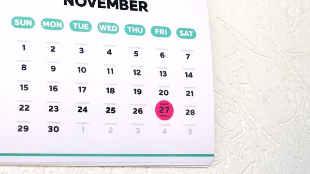 Fast camera zoom on Black Friday 2026 date on a wall calendar after a hand rips away the previous month page. Holiday shopping season countdown concept