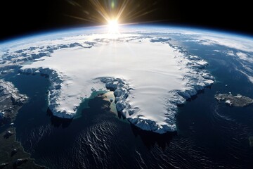 Fototapeta premium Polar orbit satellite view shows massive white ice caps on earth. Bright sun shines over frozen continent, dark blue ocean. Global warming, climate change concept with glowing sunlight on arctic